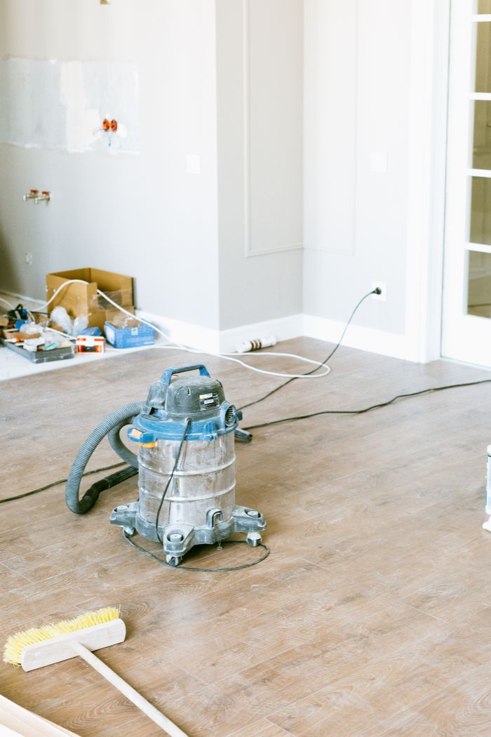 A vacuum cleaner and tools in a room under renovation, highlighting home improvement work.